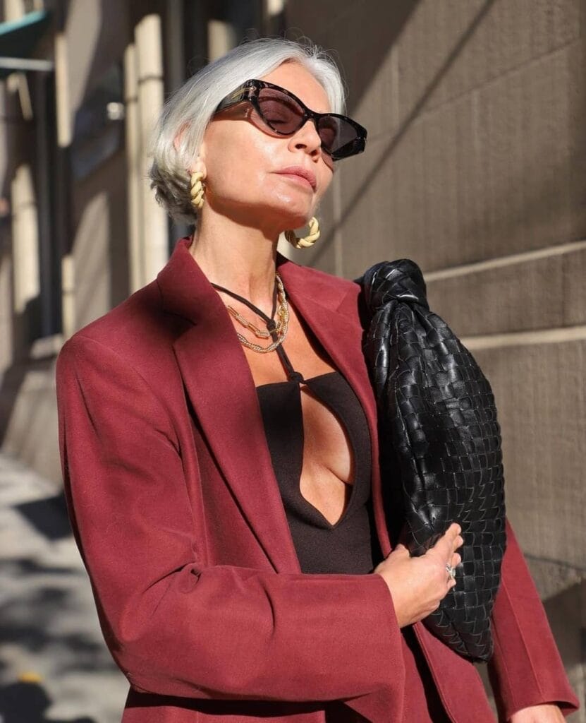 A woman with a short gray bob styled straight with tucked ends and a polished finish.