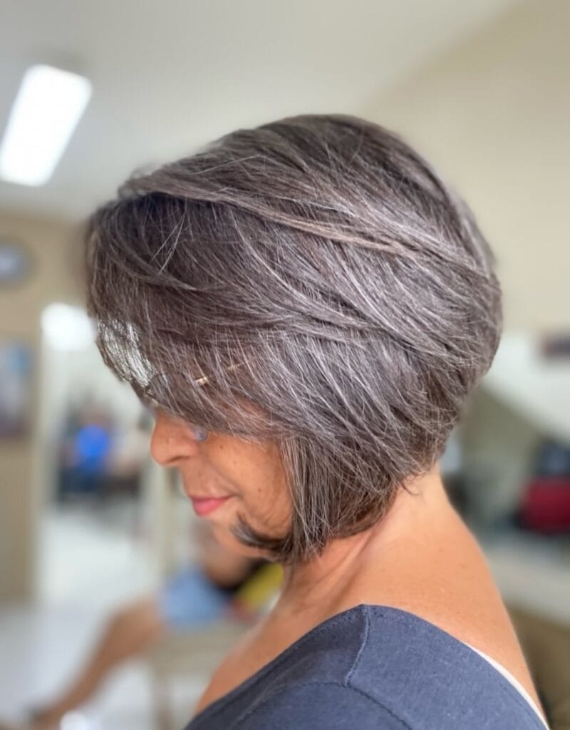 Layered gray bob with side swept volume and soft textured movement.