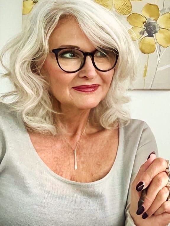 Shoulder length silver hairstyle with soft layers and gentle waves.