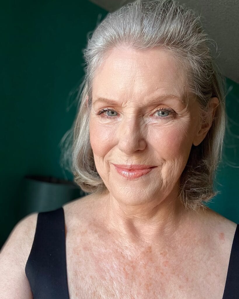 Shoulder length gray hairstyle with soft volume at the crown and lightly curved ends framing the face.