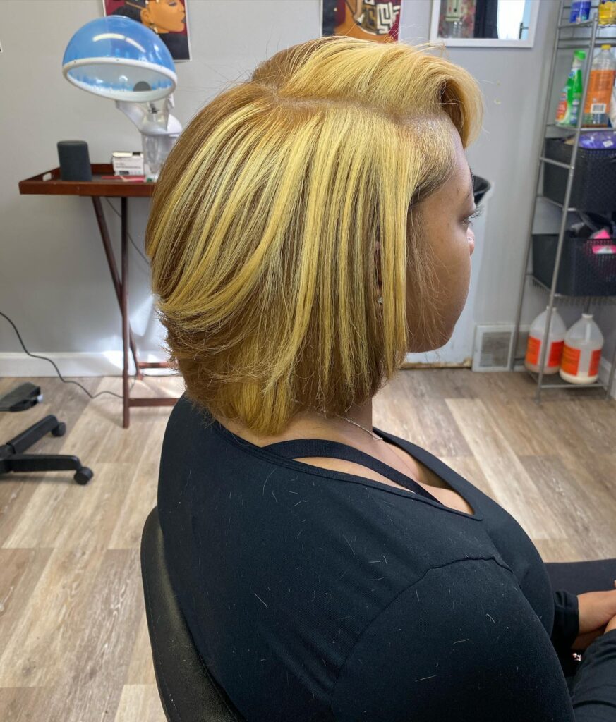 Layered blonde bob with a side sweep and softly curved ends.