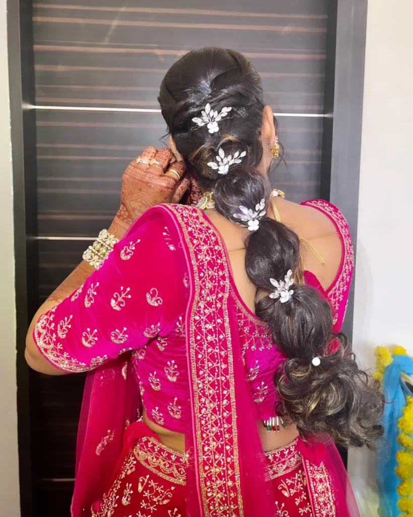 Dark hair styled in a voluminous bubble braid decorated with floral accessories.