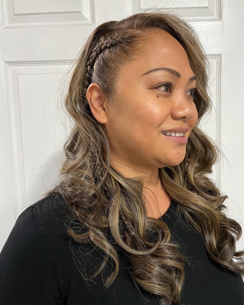 Medium length wavy hair with a small side braid and soft highlights.