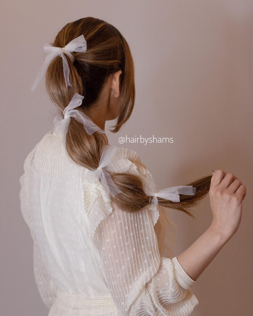 A low bubble braid tied with sheer ribbon bows along the length.