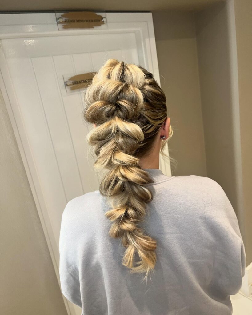 A chunky textured bubble braid with voluminous sections on blonde hair.