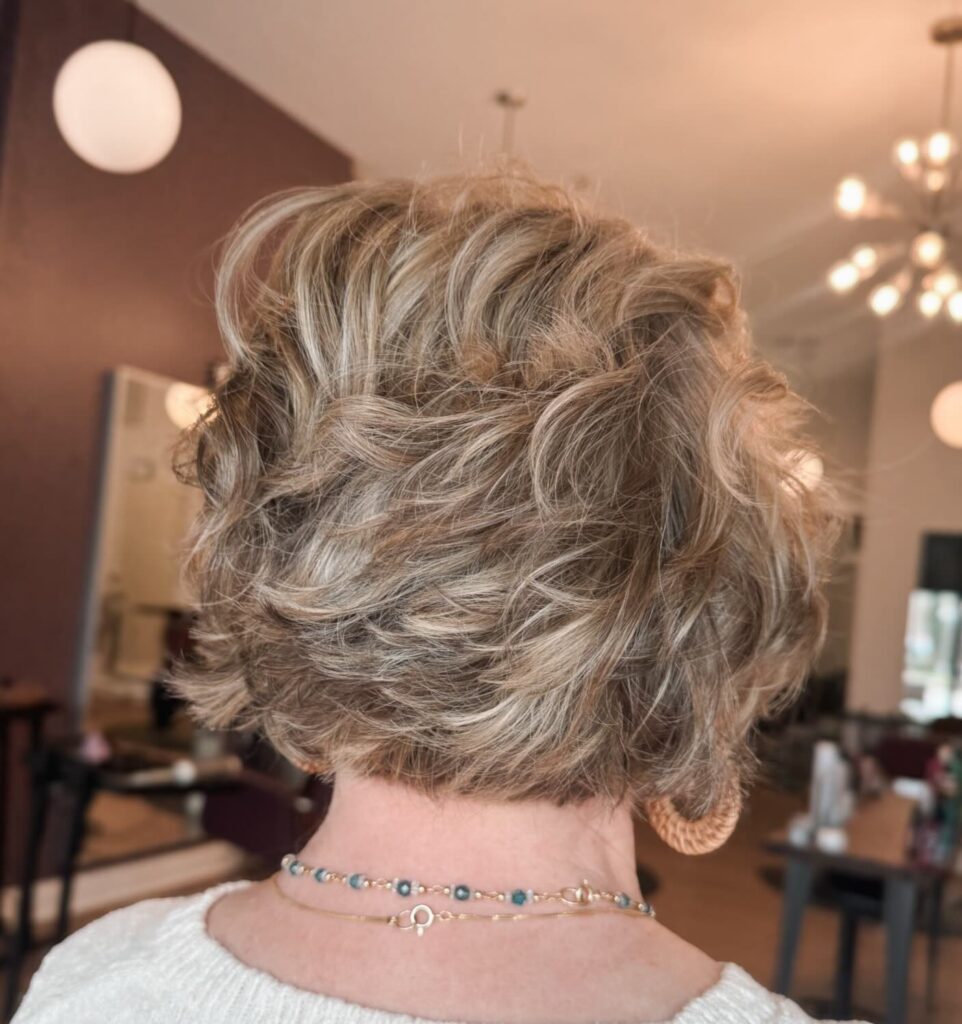 Short shaggy bob with feathered blonde layers and soft textured volume at the back.