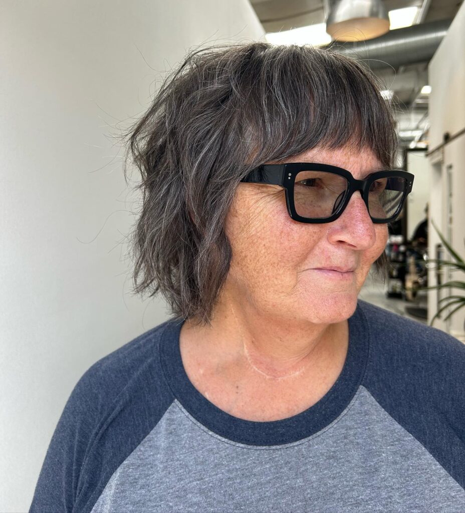 Charcoal gray shaggy bob with wispy bangs and soft choppy layers.