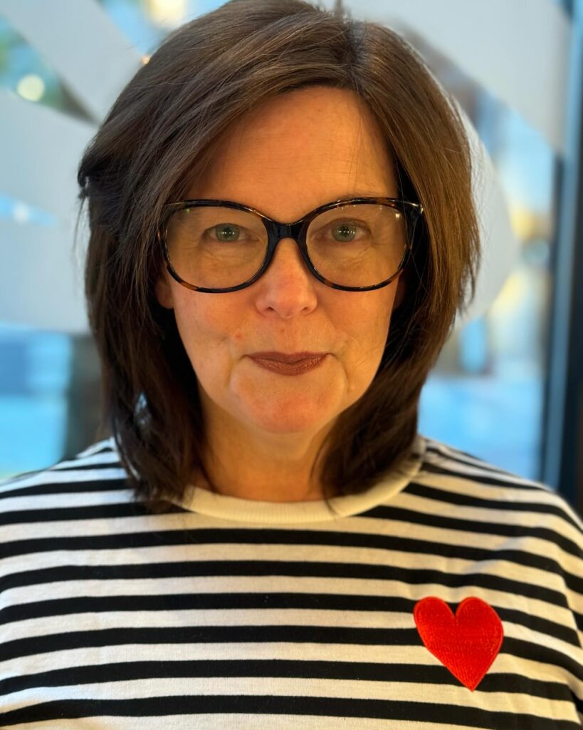 Smooth brunette layered bob with side-swept volume and soft ends.