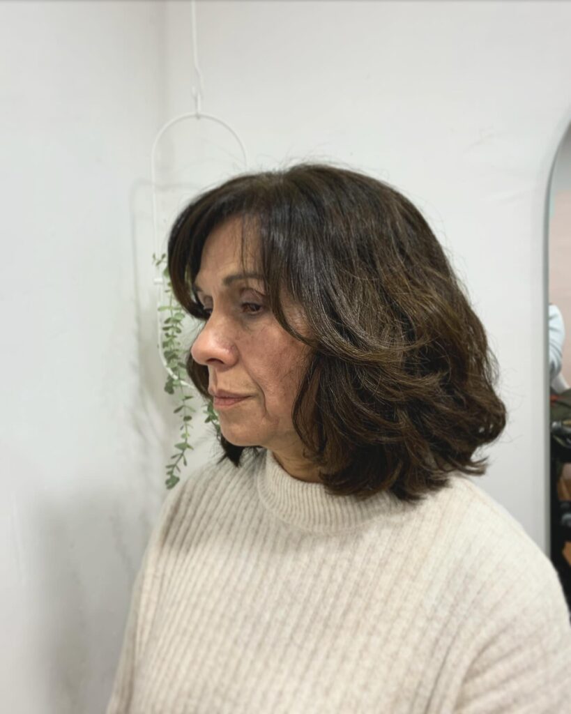 Dark shaggy bob with soft feathered layers and flipped-out ends.