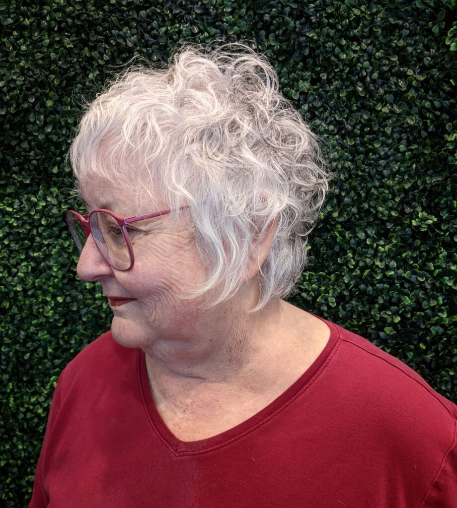 Short curly white shag haircut with soft wispy layers and textured volume.