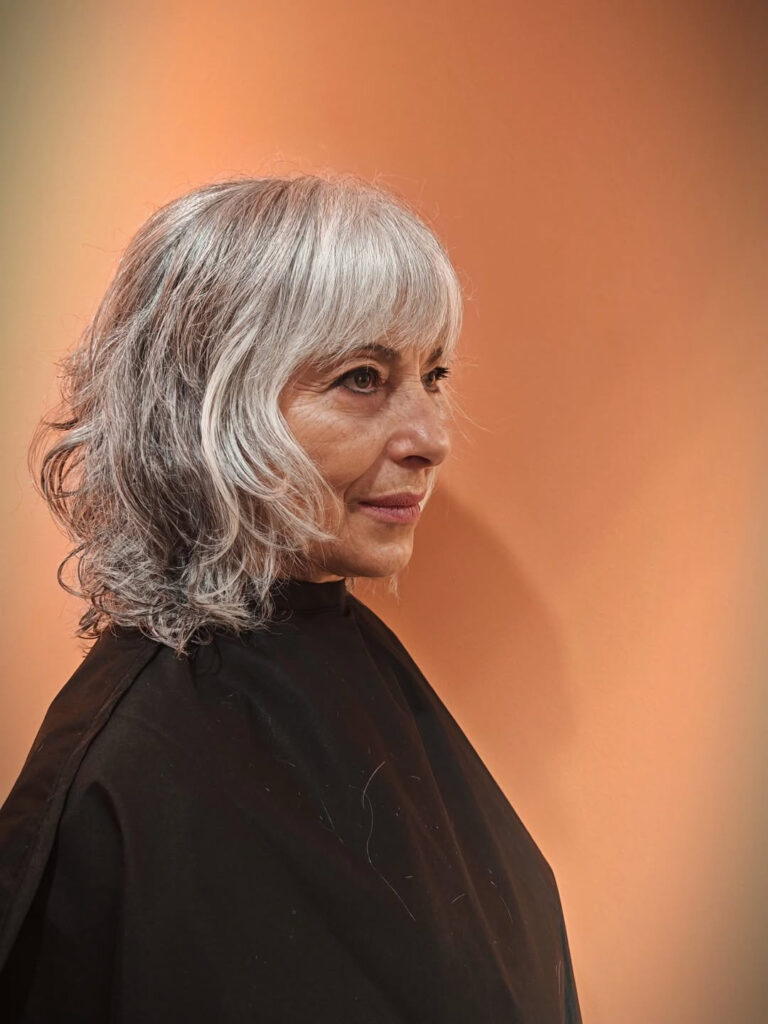 Silver shaggy bob with loose waves, fringe, and textured layers.