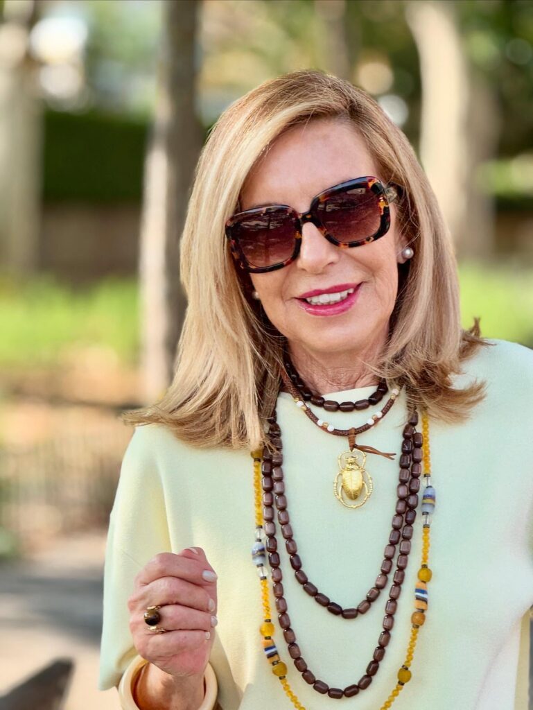 A woman wearing sunglasses with a honey blonde lob featuring flipped-out ends.