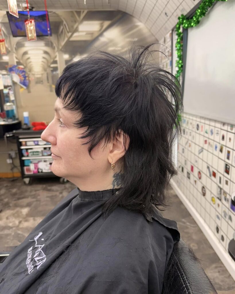 Black spiky mullet haircut with layered texture and longer back pieces.
