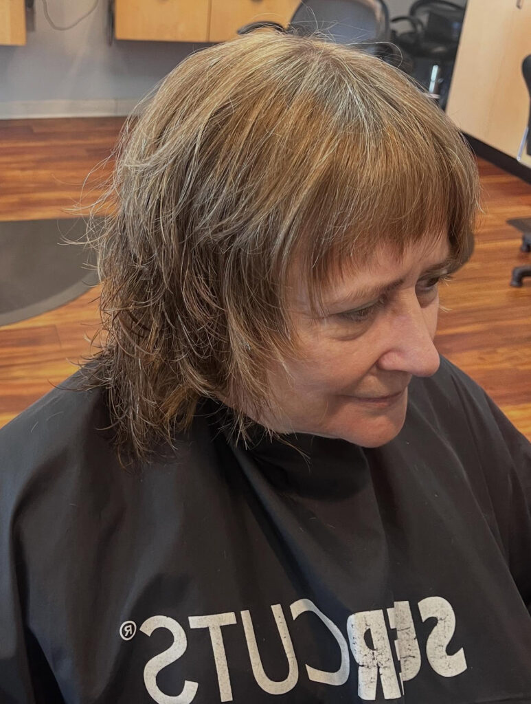 Layered shag bob with wispy bangs and soft choppy brunette texture.