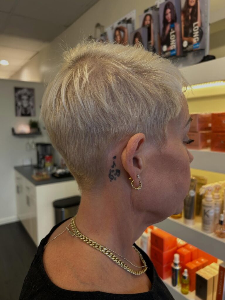 Short platinum pixie haircut with tapered sides and textured layers.