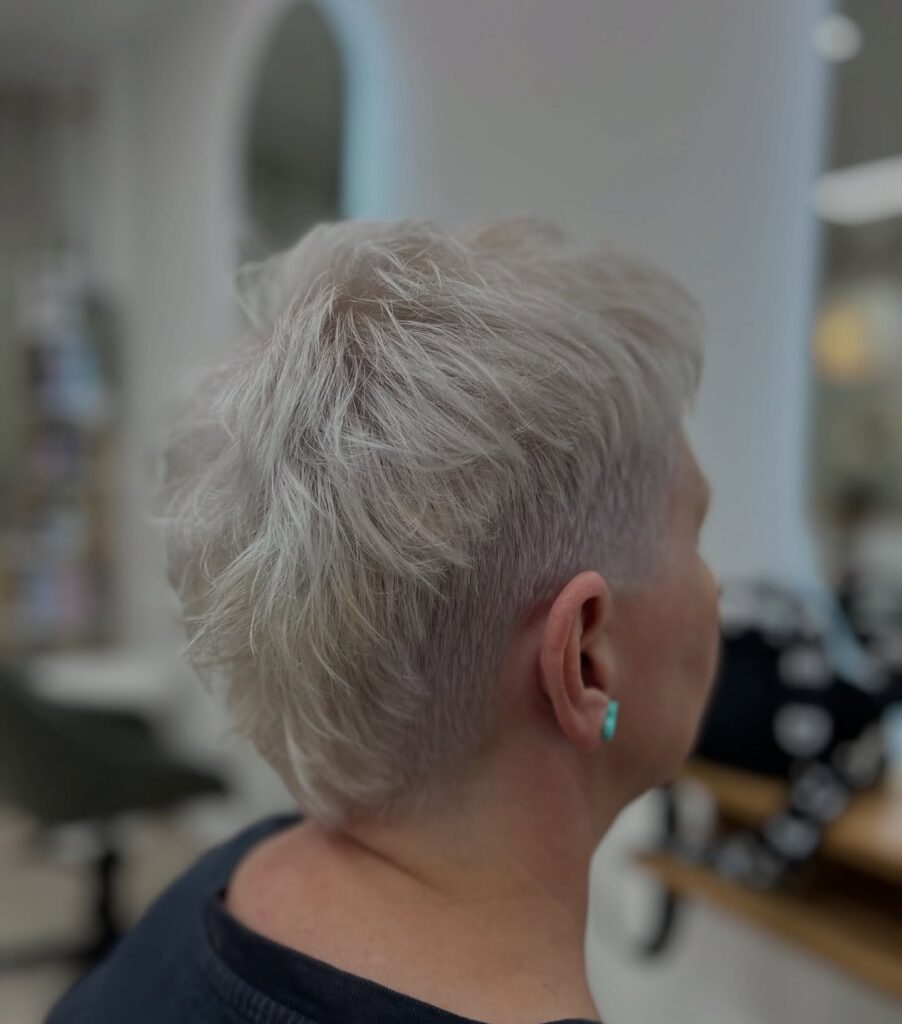 Short frosted pixie haircut with textured layers and tapered sides.