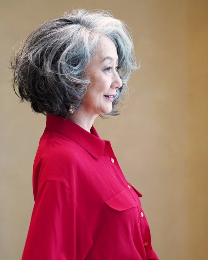 Short curled bob with gray and silver tones styled with a smooth side sweep.