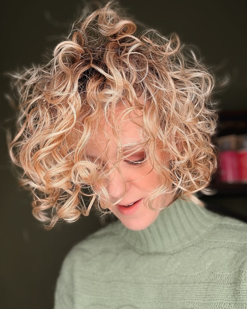 Chin length curly bob with soft blonde curls and lively layered texture.