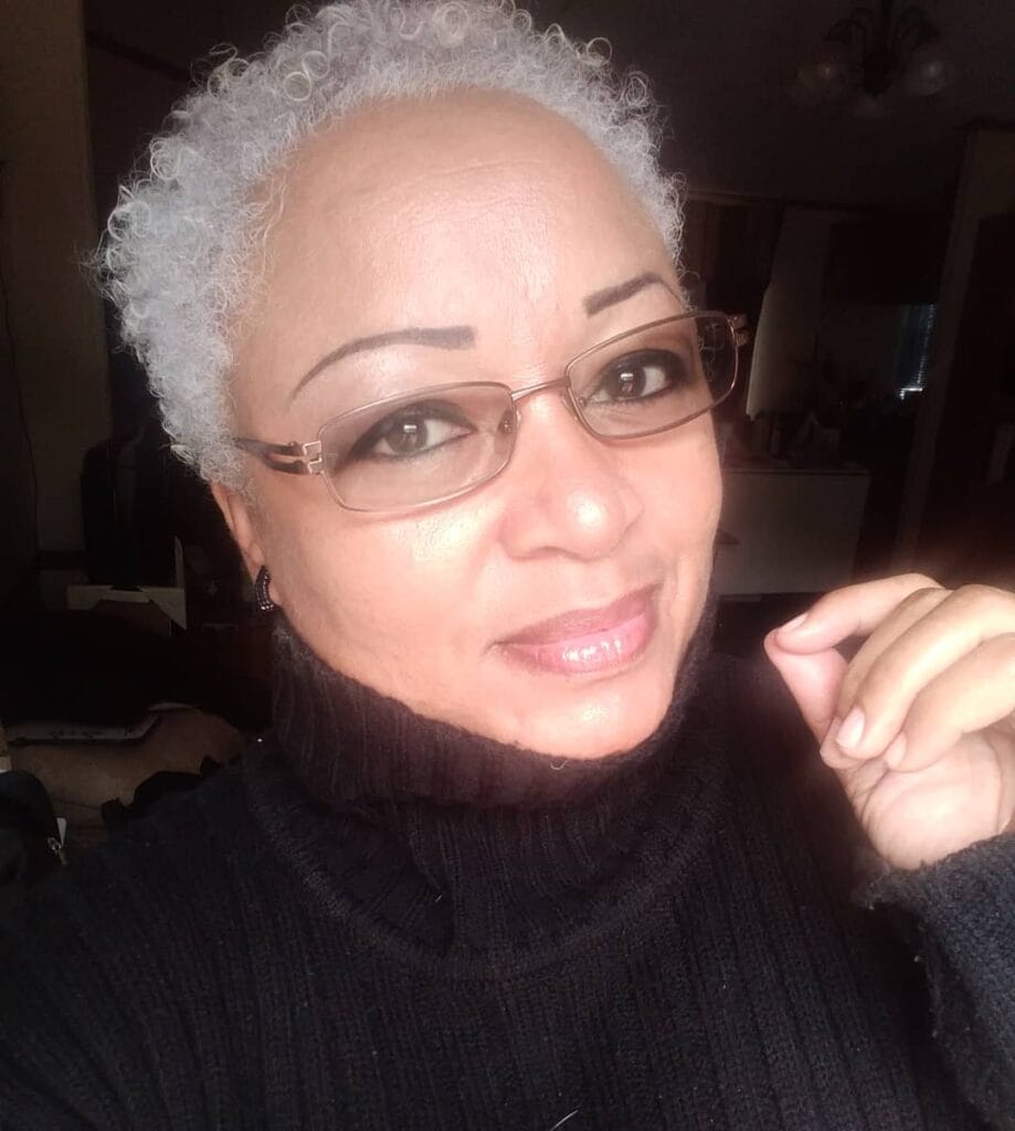 Short silver curly cropped hairstyle with tight natural curls and soft texture.