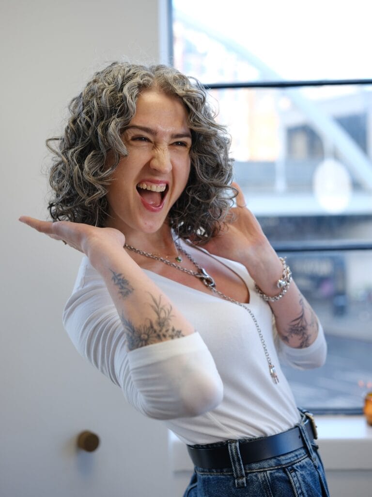 Shoulder grazing layered hairstyle with natural gray curls and relaxed texture.