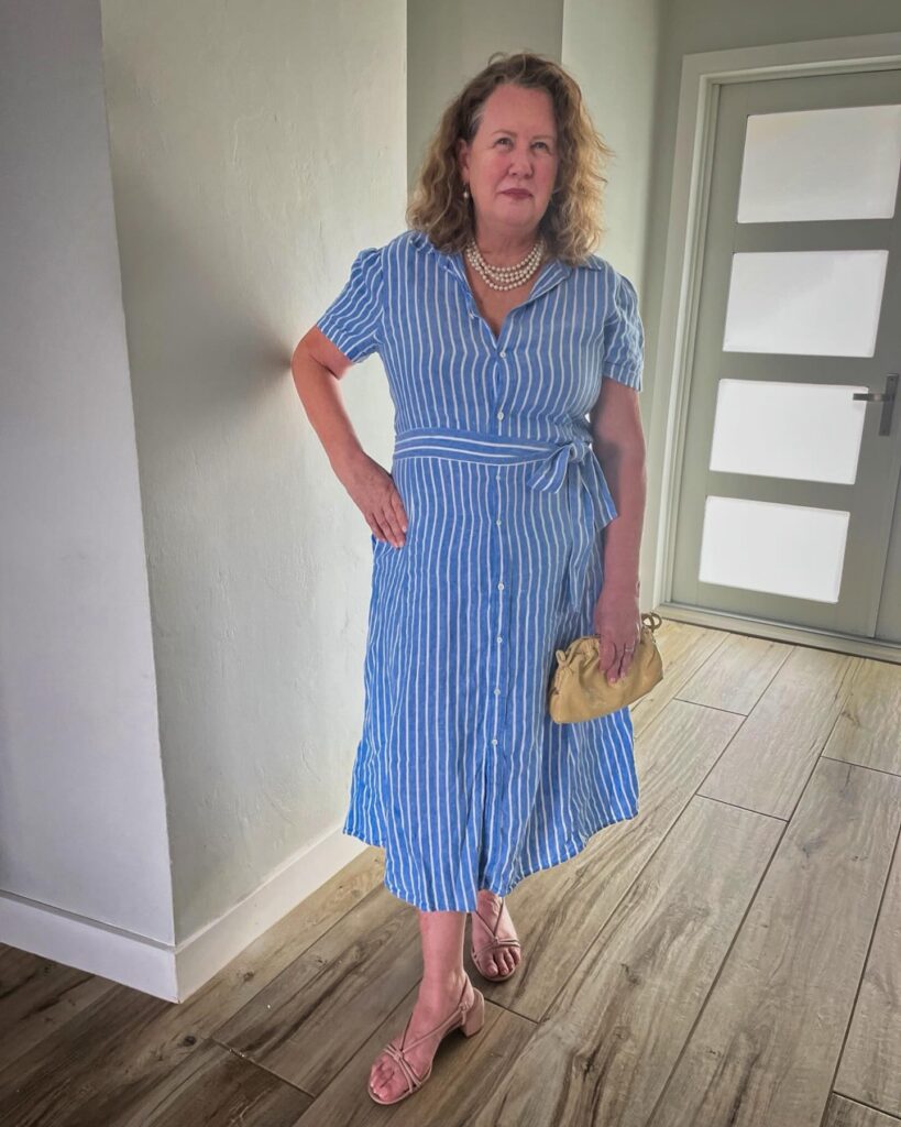 A woman over 60 with a shoulder-length honey blonde hairstyle featuring natural curls and a side part.