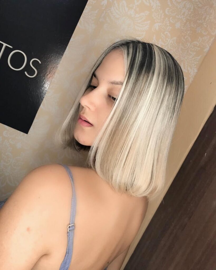 Straight platinum bob with dark roots and bold split dye front sections.