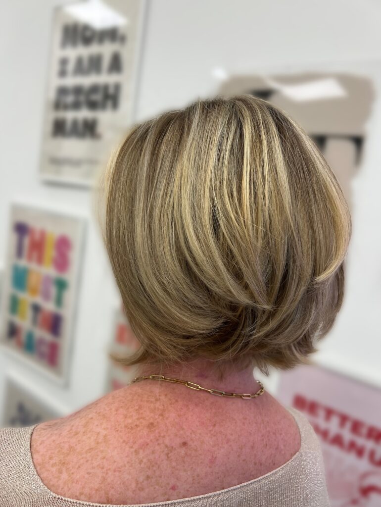 Layered blonde bob with soft volume and flipped out ends.