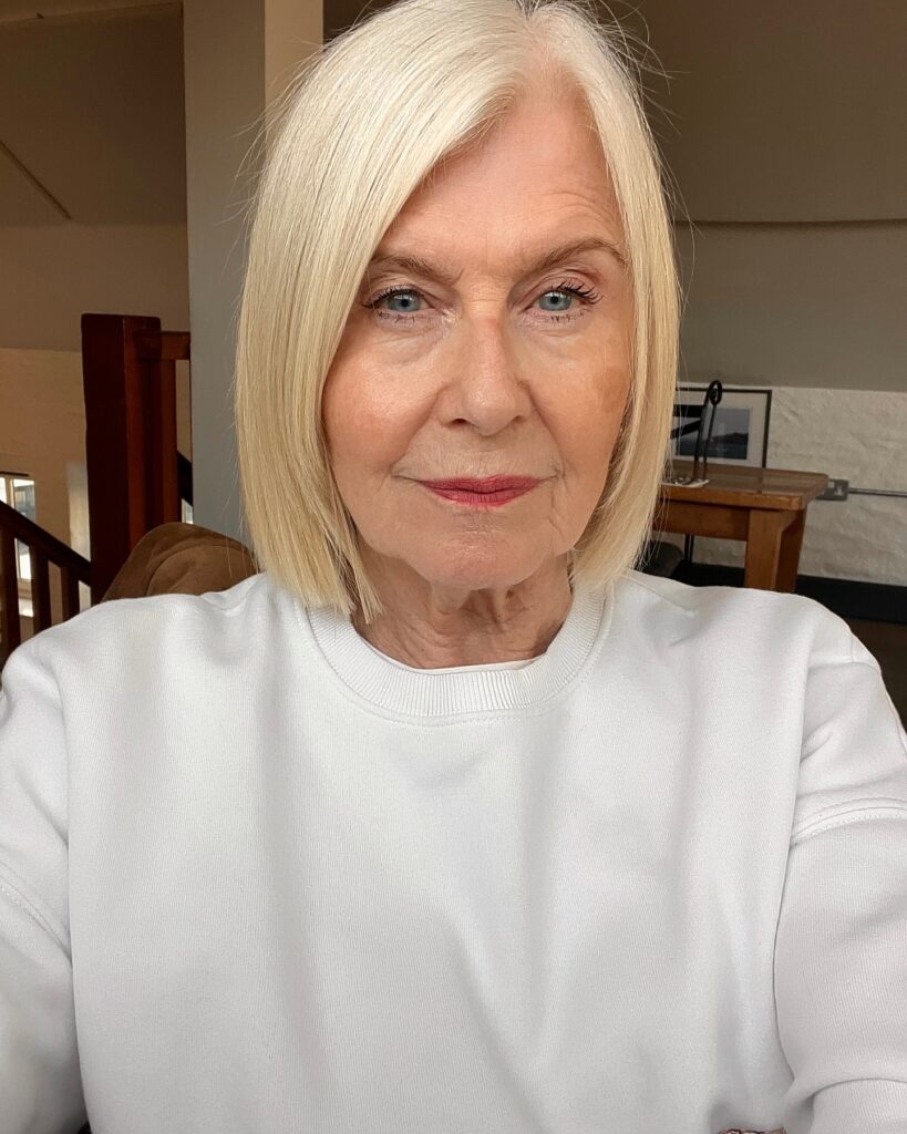 A woman with a straight, jaw-length platinum blonde bob styled with a side part and no bangs.