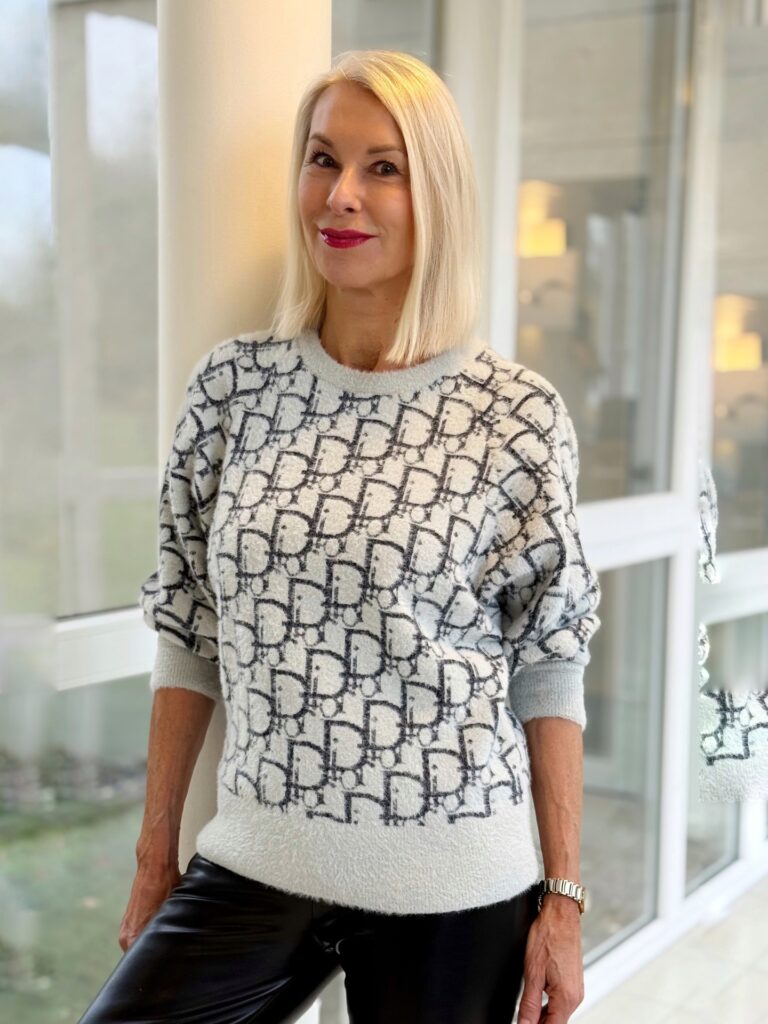 A woman over 60 with a sleek blunt-cut lob in a creamy blonde shade styled with a side part and no bangs.