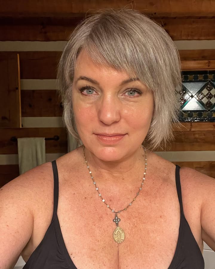 Short layered silver bob with side swept bangs and a soft textured finish.