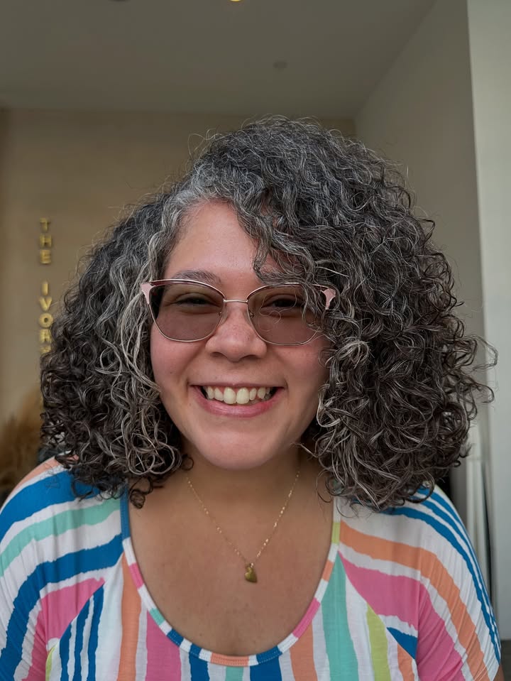Shoulder length curly bob with layered dark curls and soft volume.
