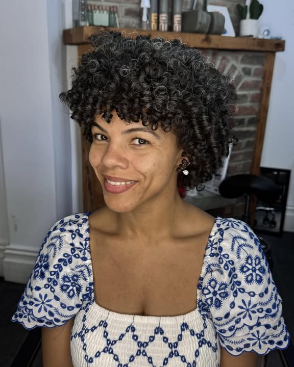 Short curly bob with a rounded shape and soft curly fringe framing the face.
