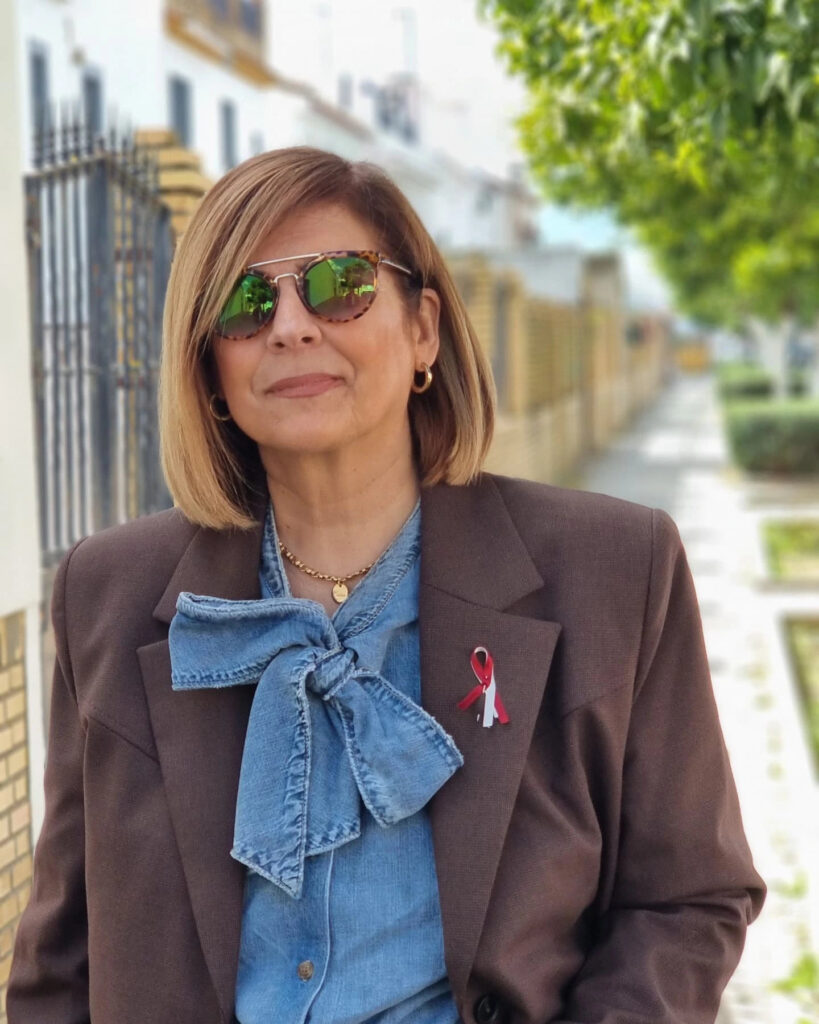 A woman wearing tortoiseshell sunglasses and a brown blazer displays a sleek honey blonde lob with a deep side part.