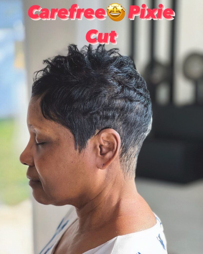 A profile view of a woman with a dark spiky pixie cut featuring textured layers on top and a clean tapered fade at the nape of the neck.