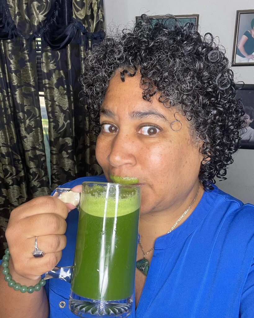 An older Black woman with a glossy ear-length curly hairstyle in salt-and-pepper grey with soft curly bangs.