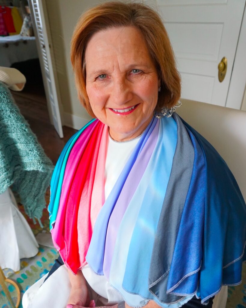 A smiling woman with a chin-length honey-copper bob and a soft side part.