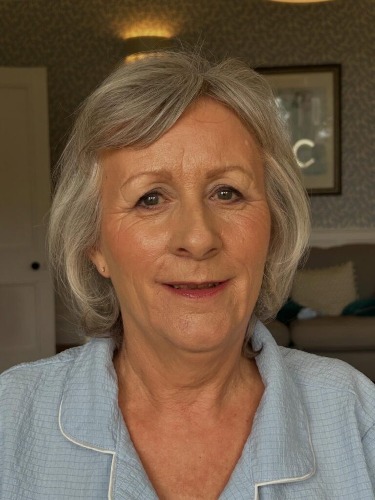 A woman over 60 with a soft grey bob hairstyle featuring feathered layers and side-swept bangs.