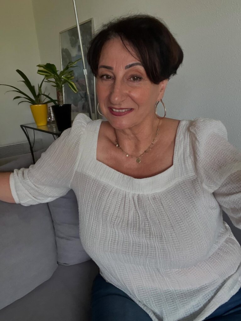 A woman over 60 with a classy dark espresso pixie hairstyle featuring soft volume on top and tapered sides.