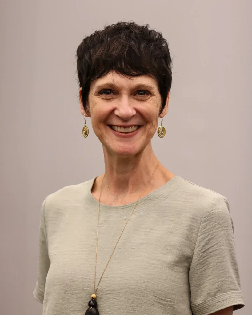 Short brunette pixie haircut with soft texture and natural volume.