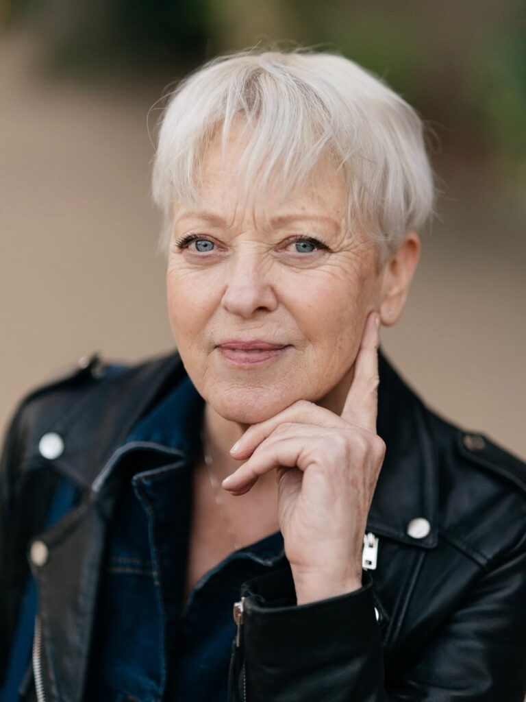 Short white pixie haircut with soft layers and a light fringe framing the face.