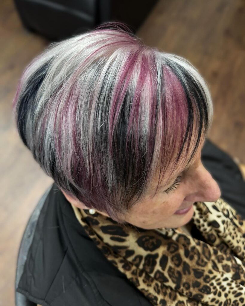 Short pixie haircut with pink and silver highlights and textured layers.