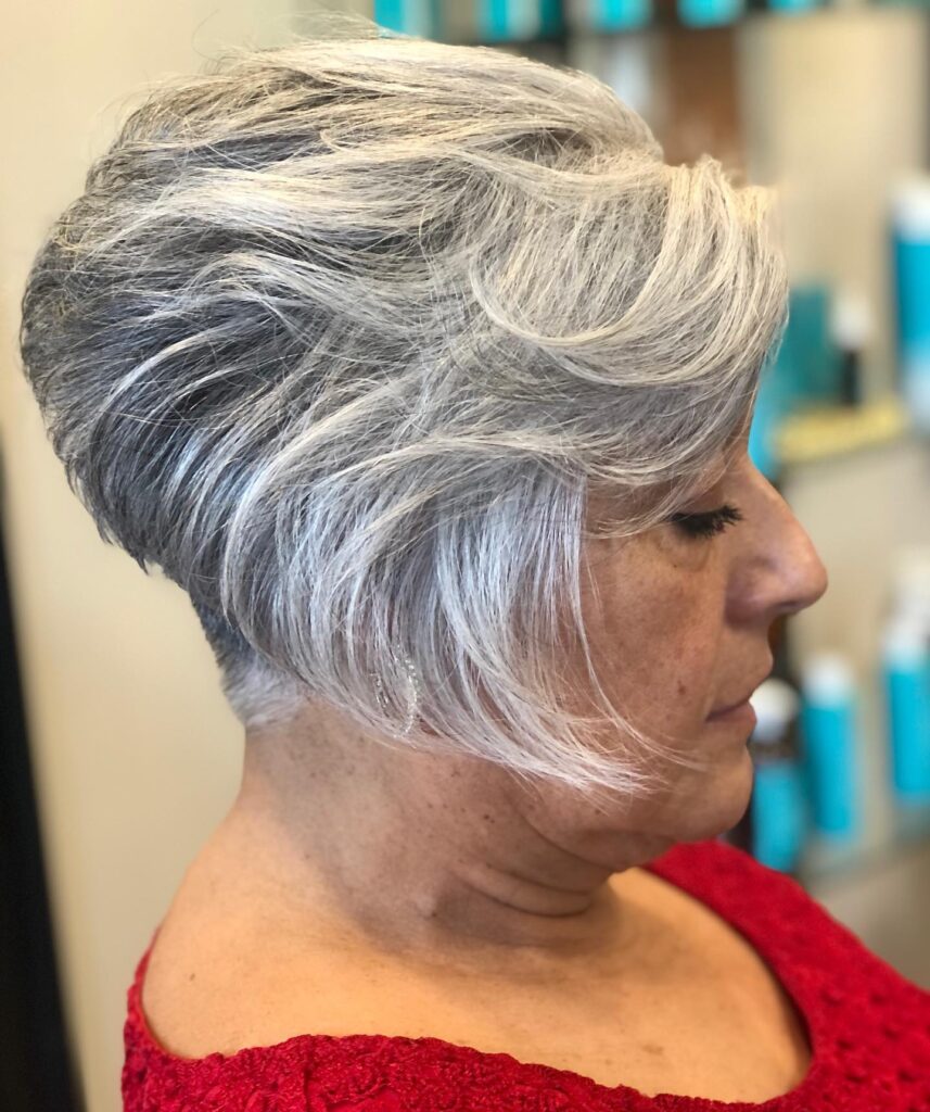 Short silver pixie haircut with layered texture and a soft side-swept fringe.
