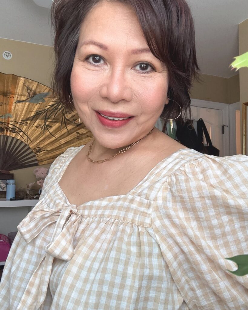 A woman over 60 with a chin-length espresso brown bob featuring soft layers and a side-swept fringe.