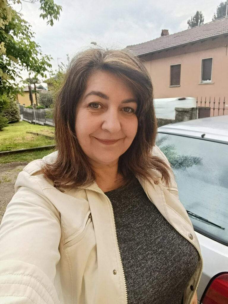 A woman over 60 with medium-length chestnut brown lob styled with a deep side part and soft layers.