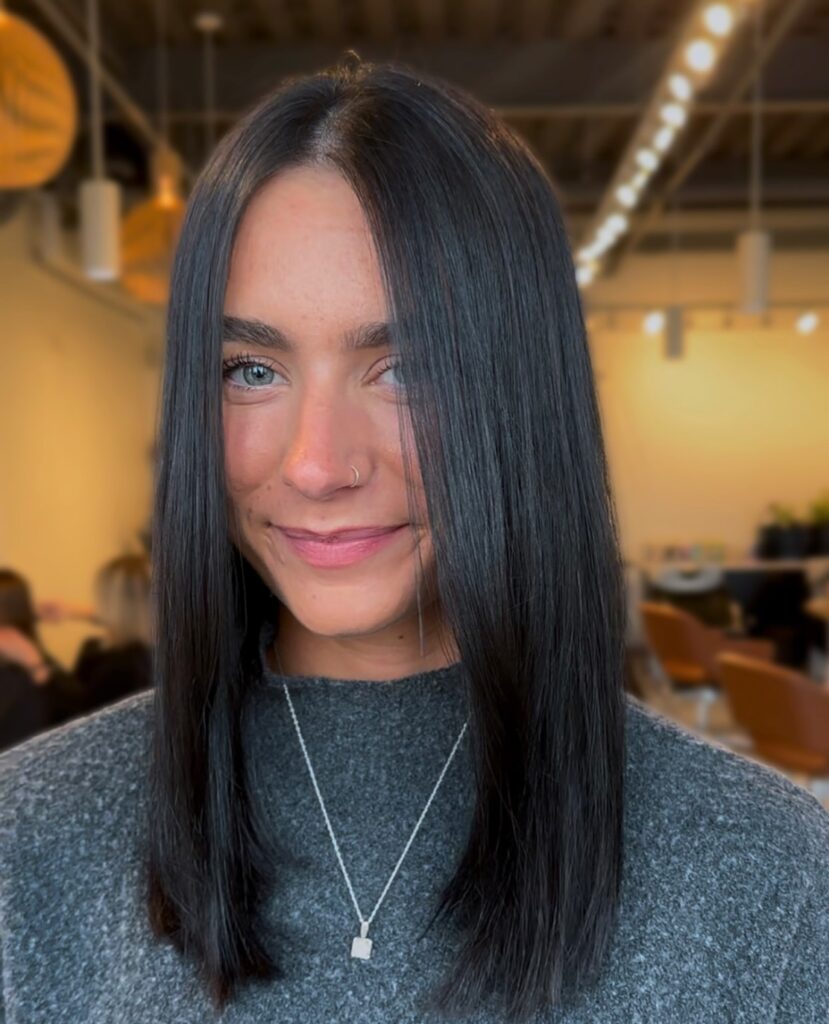 Sleek jet black long bob with a center part and blunt ends.