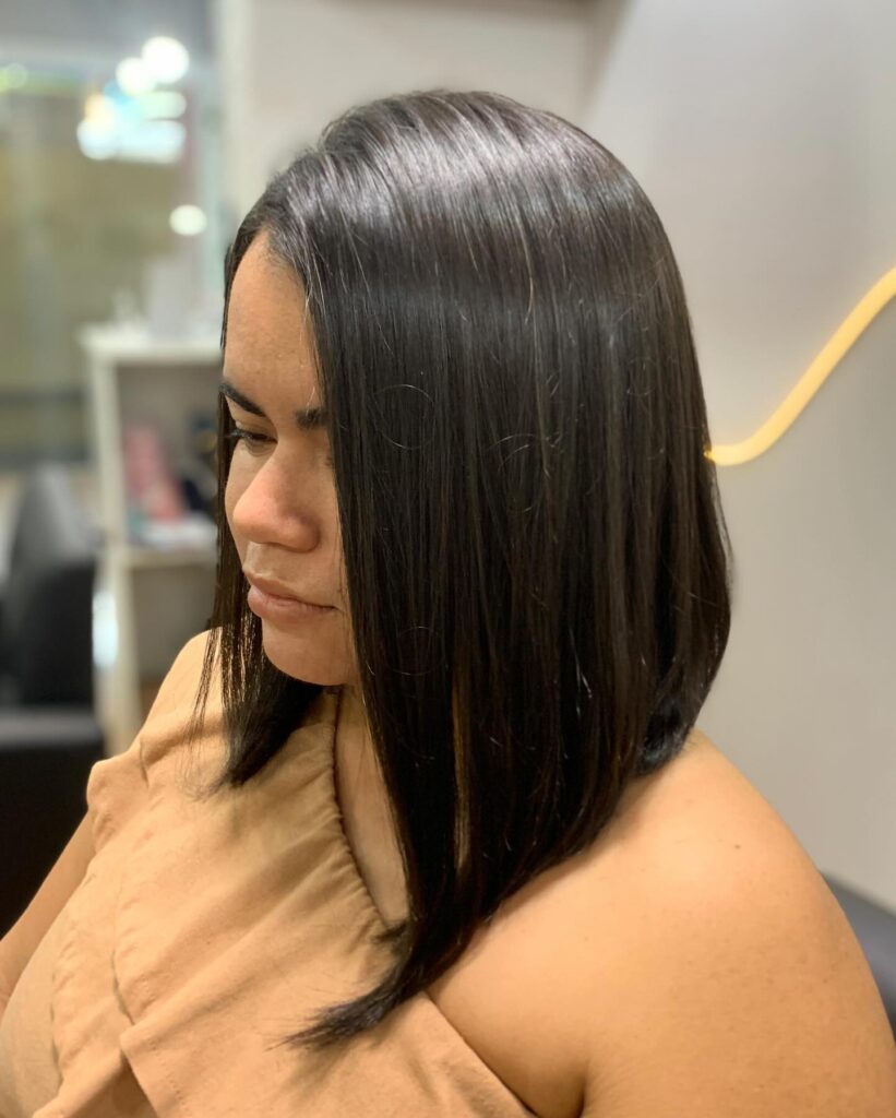 Straight shoulder length brunette long bob with subtle highlights and a sleek finish.