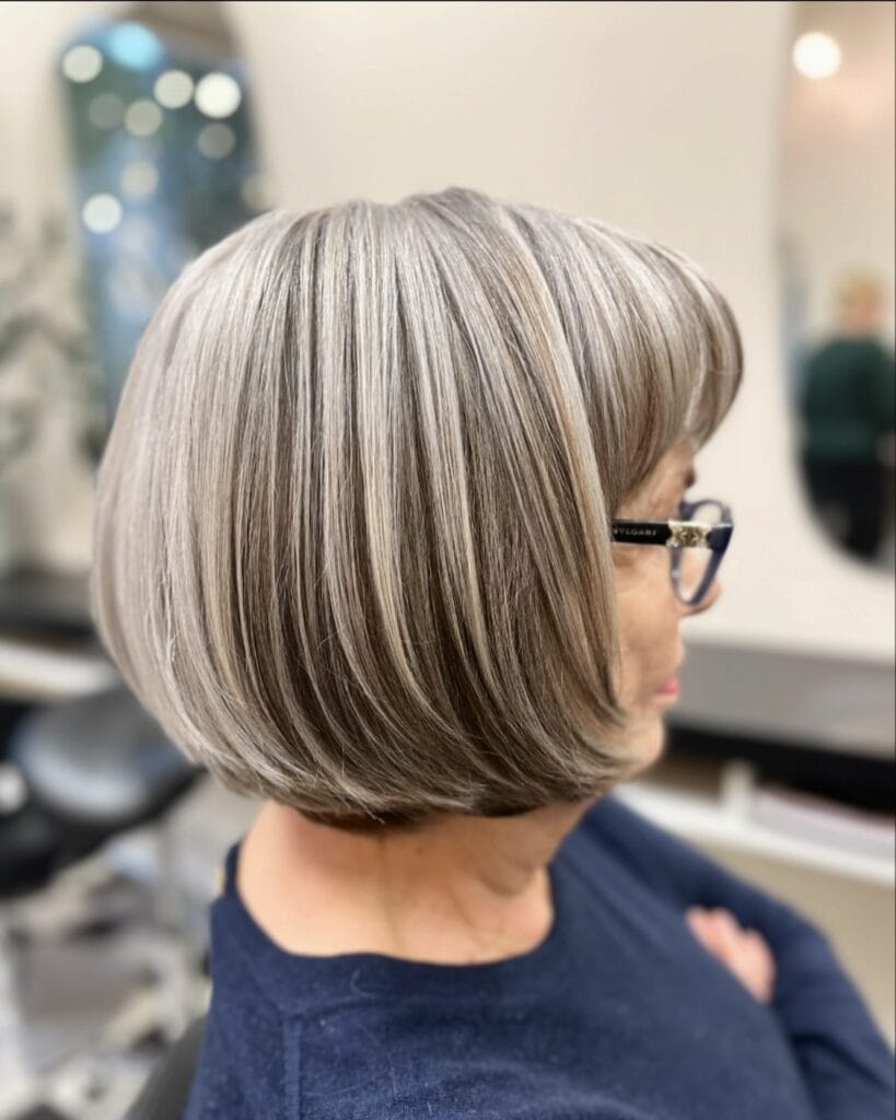 Rounded long bob with full curtain bangs and smooth tucked under ends.