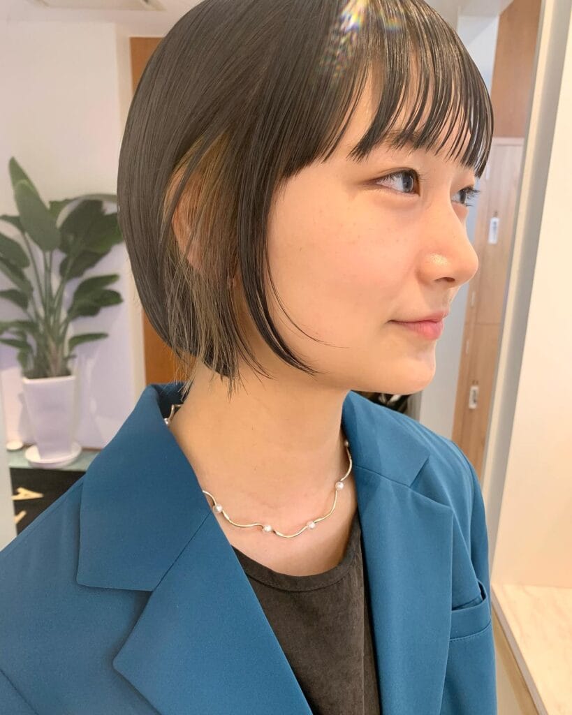 Layered long bob with wispy curtain bangs and soft natural texture.