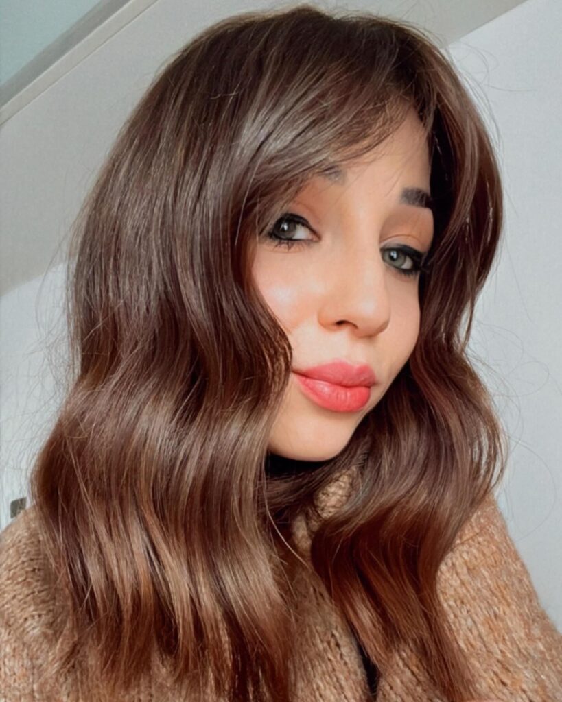 Long bob in deep chocolate brown with soft loose waves and a glossy finish.