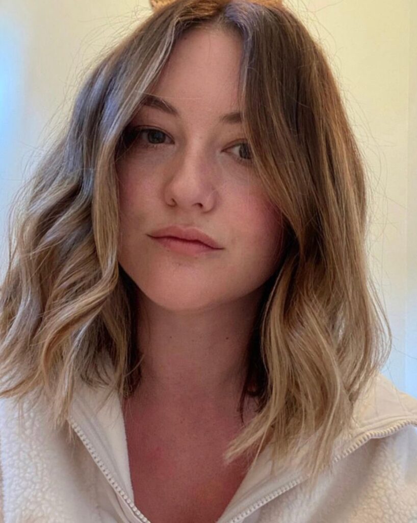 Blonde long bob with loose waves and soft layered texture around the shoulders.